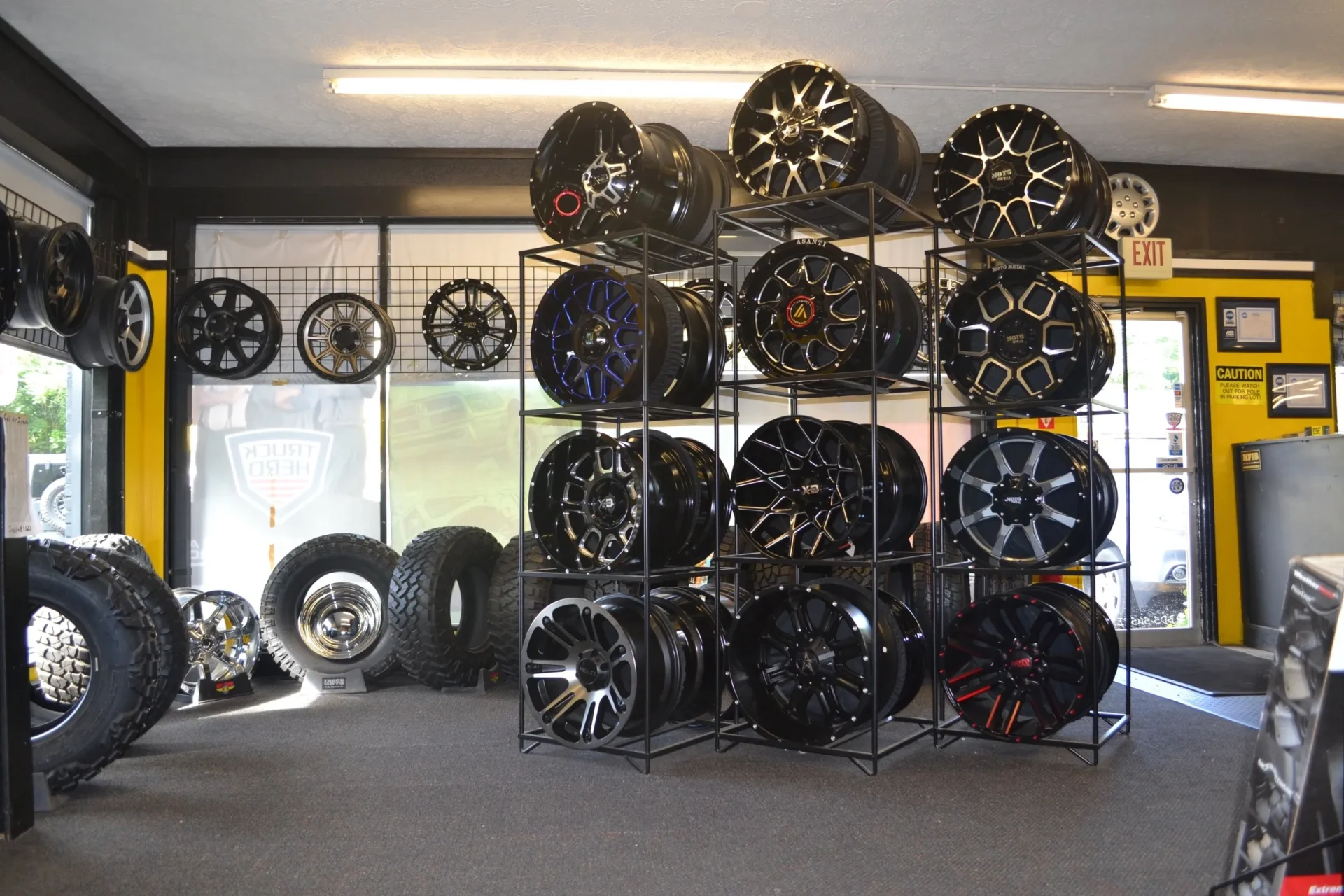An array of various car wheels displayed in a tire shop.